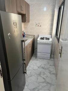 a kitchen with a refrigerator and a stove at Zac Mbao appartement meuble in Mbaw