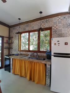 a kitchen with a sink and a refrigerator at Casa da Ponte, Trindade in Trindade