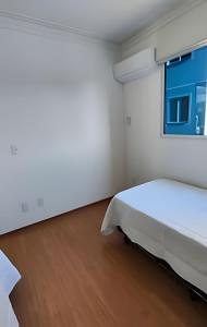 a white bedroom with a bed and a window at Paz e natureza! Descanso e tranquilidade! in Rio das Ostras