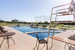 a patio with a table and chairs next to a pool at Paz e natureza! Descanso e tranquilidade! in Rio das Ostras +71 photos