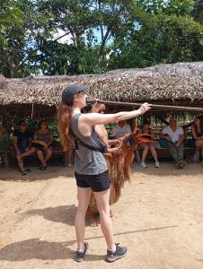 a woman holding a animal in front of a group of people at Amazon Macambo Lodge in Iquitos