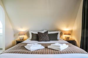 a bedroom with a bed with two towels on it at Le Gîte du Haras in Falaën