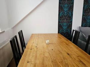 a wooden table with chairs and a glass on it at Dachgeschosswohnung in historischem Monument in Görlitz