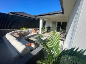 a patio with a couch and a plant on a house at Guest house Que Sera in Cooranbong