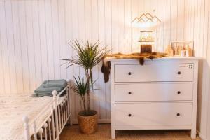 a white bedroom with a crib and a dresser at Hishka Ishka Love in Iška