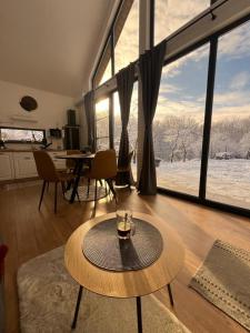 a living room with a table and a large window at Arbor in Vadu Crişului