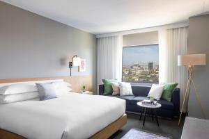 a hotel room with a bed and a couch at Kimpton Everly Hotel Hollywood by IHG in Los Angeles