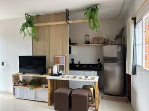 a kitchen with a refrigerator and a table with chairs at Flat Dourado a 5minutos do Parnaíba Shopping in Parnaíba