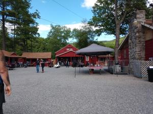 a group of people standing outside of a red barn at Do-Rest Court in Lake George