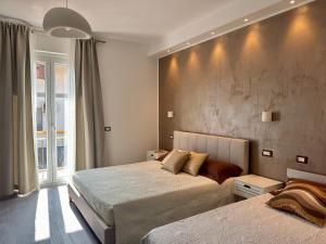 a bedroom with two beds and a concrete wall at Perla di Mare in Martinsicuro