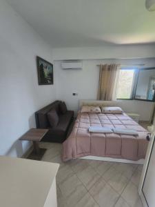 a bedroom with a large bed and a couch at Apartment 2 by Villa Ceni in Elbasan