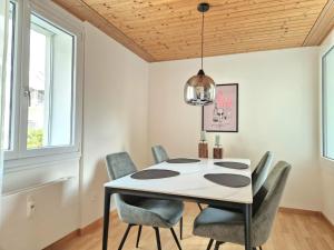 a dining room with a white table and chairs at Lakeview-Apartment - Komplette Wohnung mit Seeblick an ruhiger Lage in Weesen