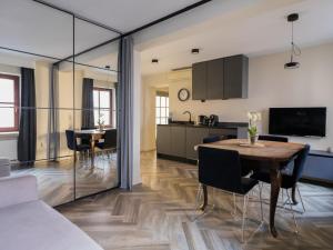 a kitchen and living room with a table and chairs at Arte-locum Apartamenty przy Rynku in Wrocław