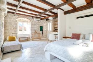 a bedroom with a large bed and a stone wall at Best view! Rooftop with Garden - Old Town Nr404 in Kotor