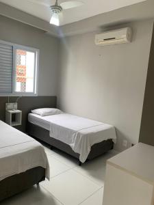 a bedroom with two beds and a air conditioner at Apartamento 500m Praia da Enseada Guarujá varanda e vaga de garagem in Guarujá +45 photos