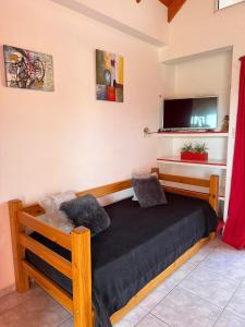 a bedroom with a bed and a tv on the wall at AltoRojo in Villa Elisa