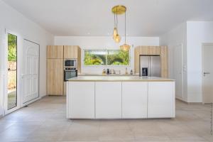 a kitchen with white cabinets and a kitchen island at Villa Andrea in Case-Pilote