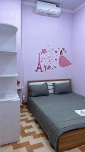 a bedroom with a bed and a painting of the eiffel tower at Ryo Homestay Dốc Lể in Ba Ha