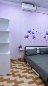 a bedroom with a bed and flowers on the wall at Ryo Homestay Dốc Lể in Ba Ha