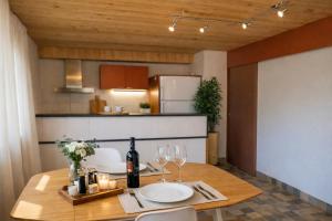 a dining room with a table with wine bottles and glasses at Maison d'Hortense - Chalet le Renard in Hérémence