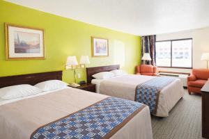 a hotel room with two beds and a chair at Gateway Inn in Sullivan