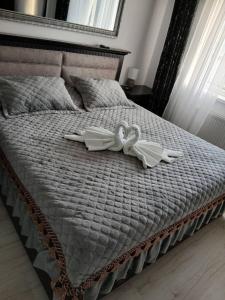 a bed with two white towels on it at Apartament Premium Militari Parcare Self Check-in in Roşu