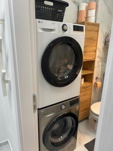 a washer and dryer in a small bathroom at Apartament Premium Militari Parcare Self Check-in in Roşu
