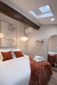 a bedroom with a large bed and a skylight at New - Appartement ou Studio Centre Ville Confort in Grasse