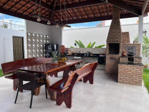 a patio with a wooden table and a brick oven at Recanto dos Maias in Aracaju