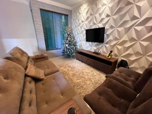 a living room with a couch and a christmas tree at Recanto dos Maias in Aracaju