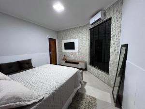 a bedroom with a bed and a tv on the wall at Recanto dos Maias in Aracaju +14 photos