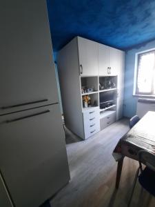 a kitchen with white cabinets and a blue ceiling at casa RIVER in Scopello