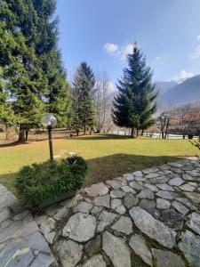 a park with trees and a stone path at casa RIVER in Scopello