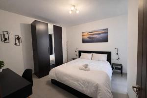 a bedroom with a bed with a stuffed animal on it at Msida Modern & Bright 2-Bedroom Apartment in Msida