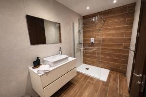 a bathroom with a sink and a glass shower at Msida Modern & Bright 2-Bedroom Apartment in Msida
