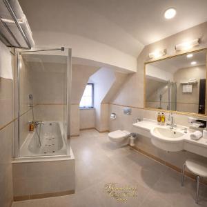 a bathroom with a tub and a sink and a toilet at Hotel Grand in Český Krumlov +71 photos