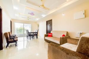a living room with a couch and chairs and a table at Capital O RR Towers by CJ in Vijayawāda
