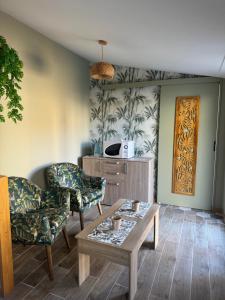a living room with two chairs and a coffee table at Suite 150 m de la mer in Luc-sur-Mer
