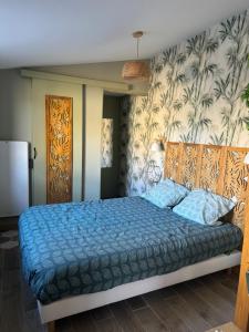 a bedroom with a bed with a blue comforter at Suite 150 m de la mer in Luc-sur-Mer