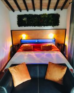 a bedroom with a large bed with orange pillows at Tudesia royal suite in Todi