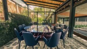 a dining room with a glass table and chairs at Orgánico Hotel Boutique VALLE DE BRAVO in Valle de Bravo