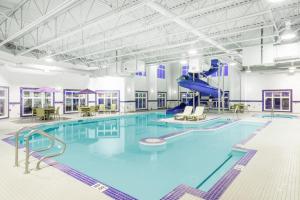 a large swimming pool with a slide in a building at Canalta Olds in Olds