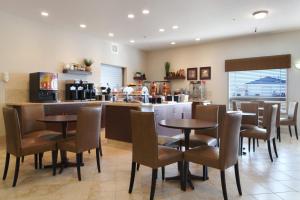 a restaurant with tables and chairs and a counter at Canalta Olds in Olds