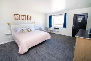 a bedroom with a bed and a table in it at The Painted Pelican in Luxemburg