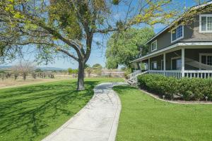 a tree in front of a house with a sidewalk at The Vineyard Farmhouse Villa in Paso Robles