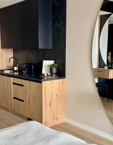 a kitchen with a counter top and black cabinets at Baltic Infinity Suite 413 - SPA & Pool Access in Międzyzdroje