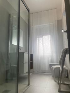 a bathroom with a glass shower and a chair at Tourgo Venice in Mestre +10 photos