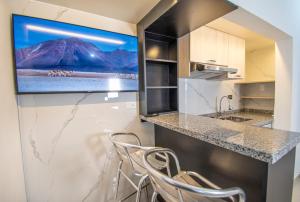 a kitchen with a counter with a tv on the wall at FRIENDLY AQP in Arequipa