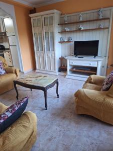 a living room with a coffee table and a tv at Piso cerca de la playa in Boiro