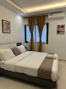 una camera da letto con un grande letto di fronte a una finestra di Confort et tranquilité a Abidjan